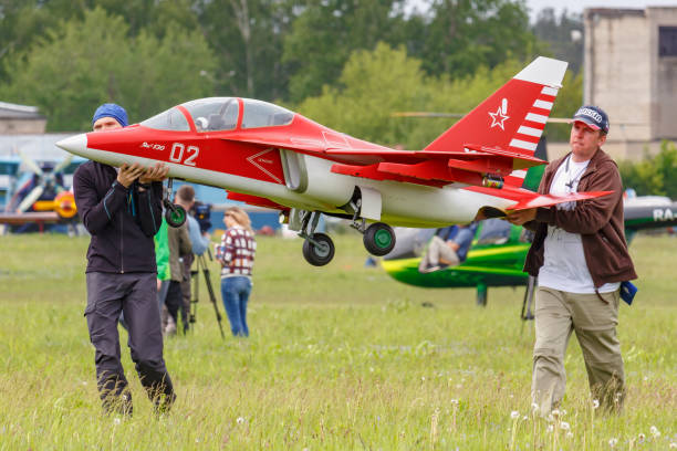 Balashikha, Moscow region, Russia - May 25, 2019: Team members of Aviation Sports Club RusJet carry a RC model of Russian jet combat-training aircraft Yak-130. Festival Sky Theory and Practice 2019
